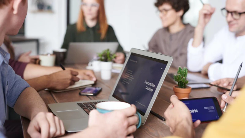 Adult in team meeting holding coffee cup